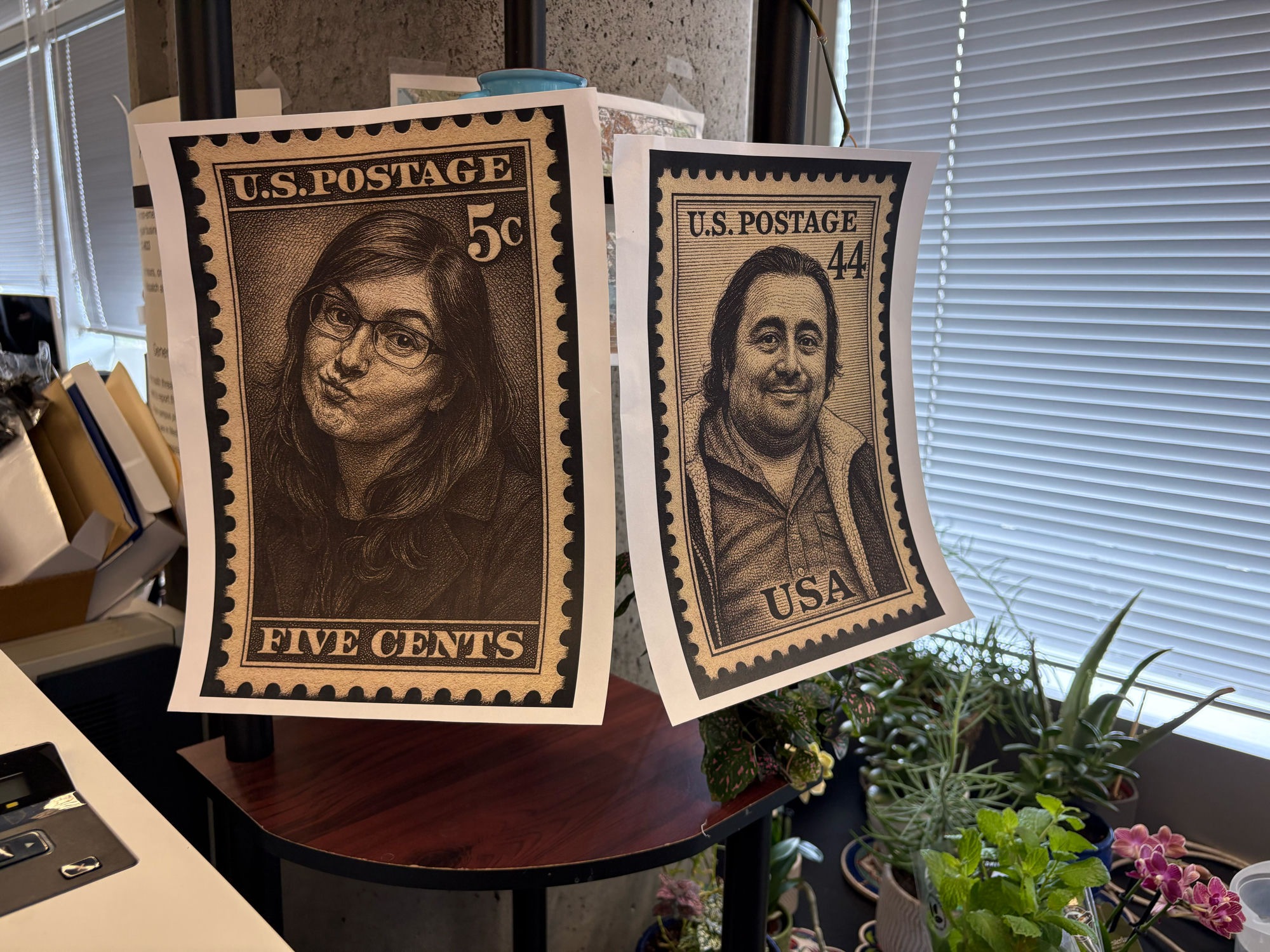 Two hand-drawn postage stamp portraits of Rachel Turn and Mohammad (Moh) Ovais Aziz-Zanjani hanging in the office